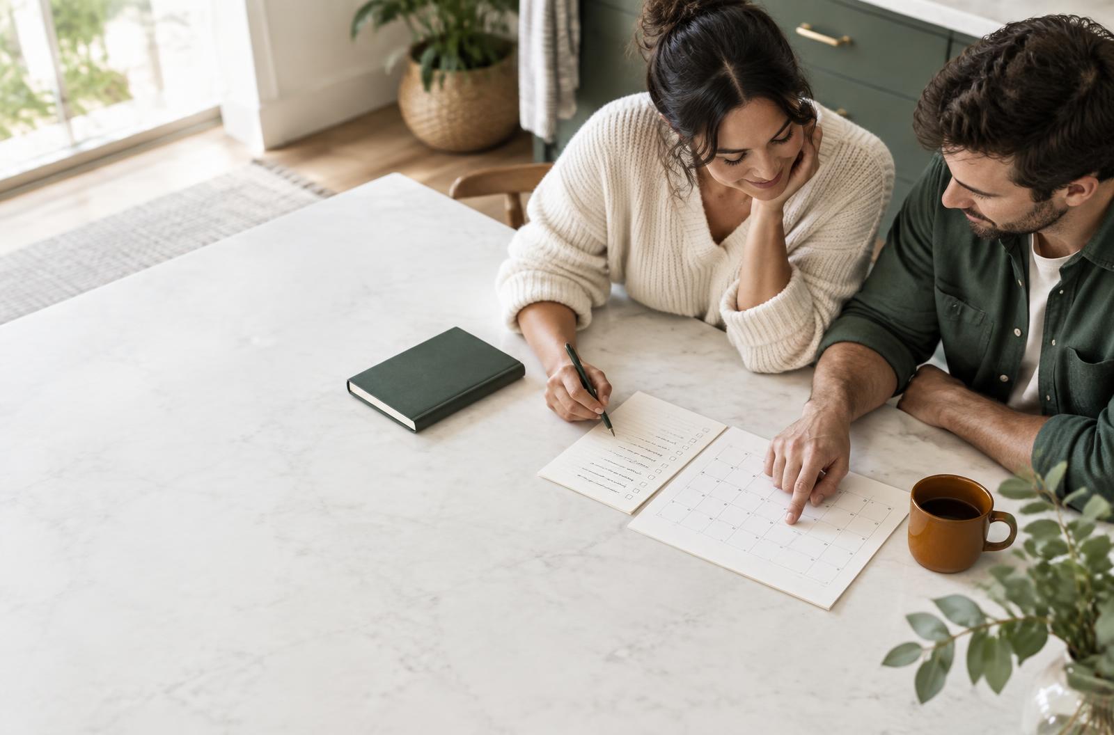 Two people planning together around a kitchen table
